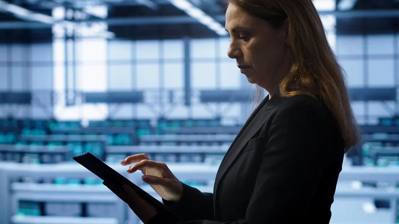 Ein Techniker führt im Server-Hub eine Kontrolle durch und gibt auf einem Tablet Daten zu den erforderlichen Reparaturen ein.